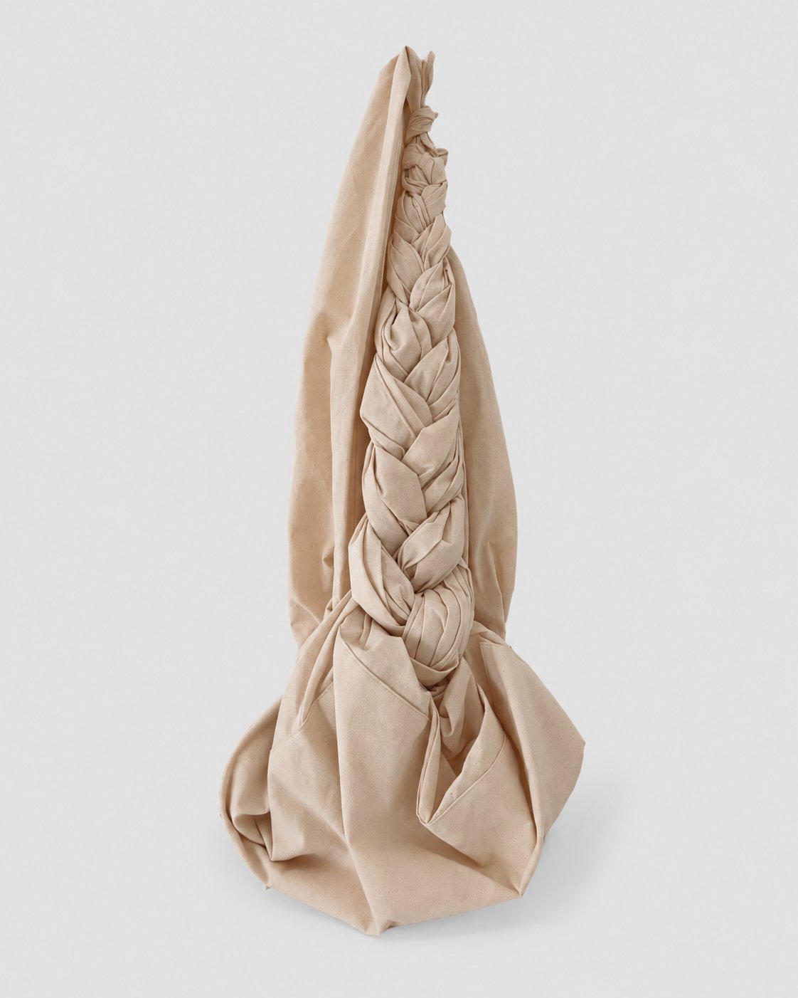 Muslin Bojagi bag with hand-knotted braided handle and draped silhouette.