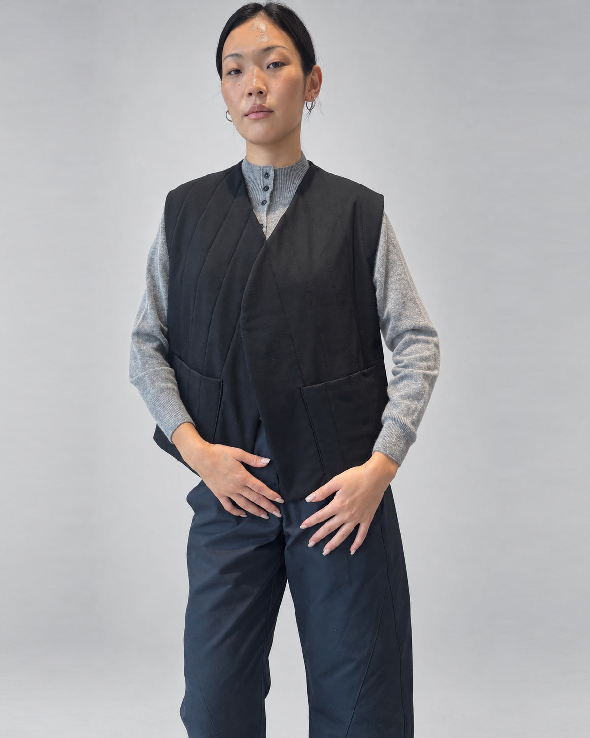 Anujin wearing Nubi Vest Classic, Black Wool — front close-up with High Neck Cardigan.