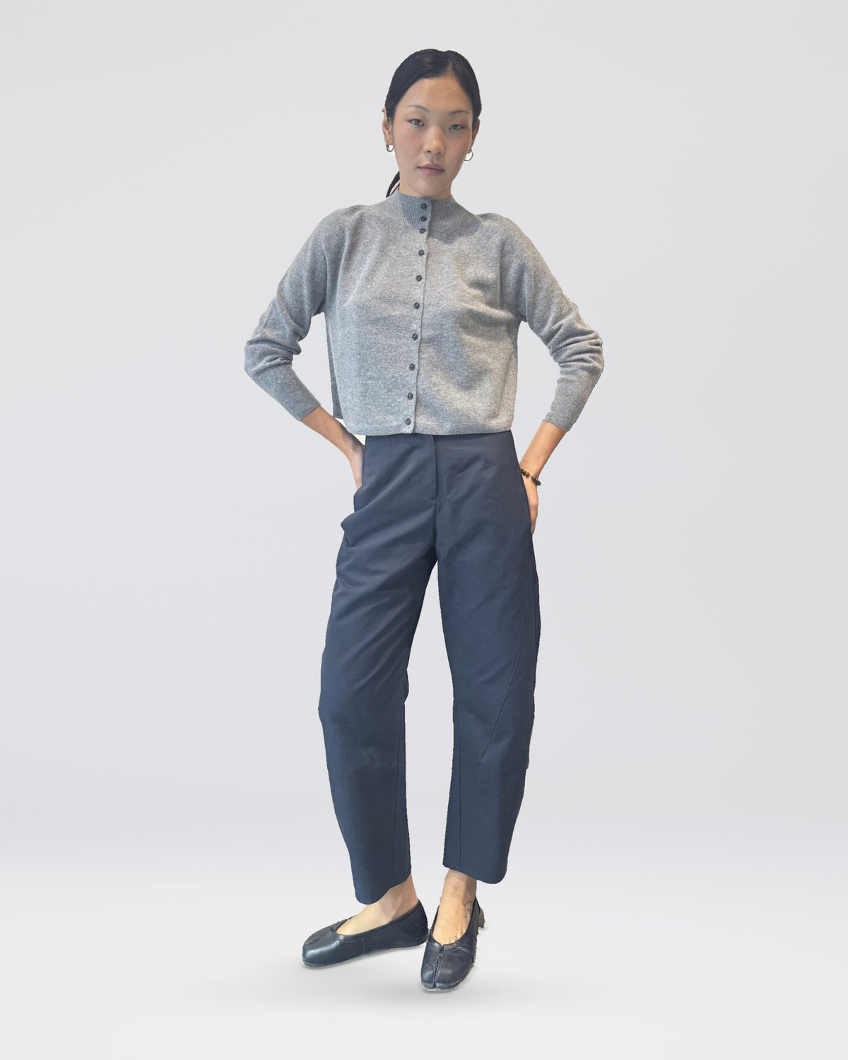 Anujin wearing High Neck Cardigan, Melange Grey, with Twist Pants Berge — front view.