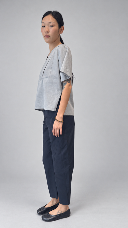 Lotus Shirt, Temple Grey — angled model view. Anujin wearing lotus shirt temple grey, twist pants berge.