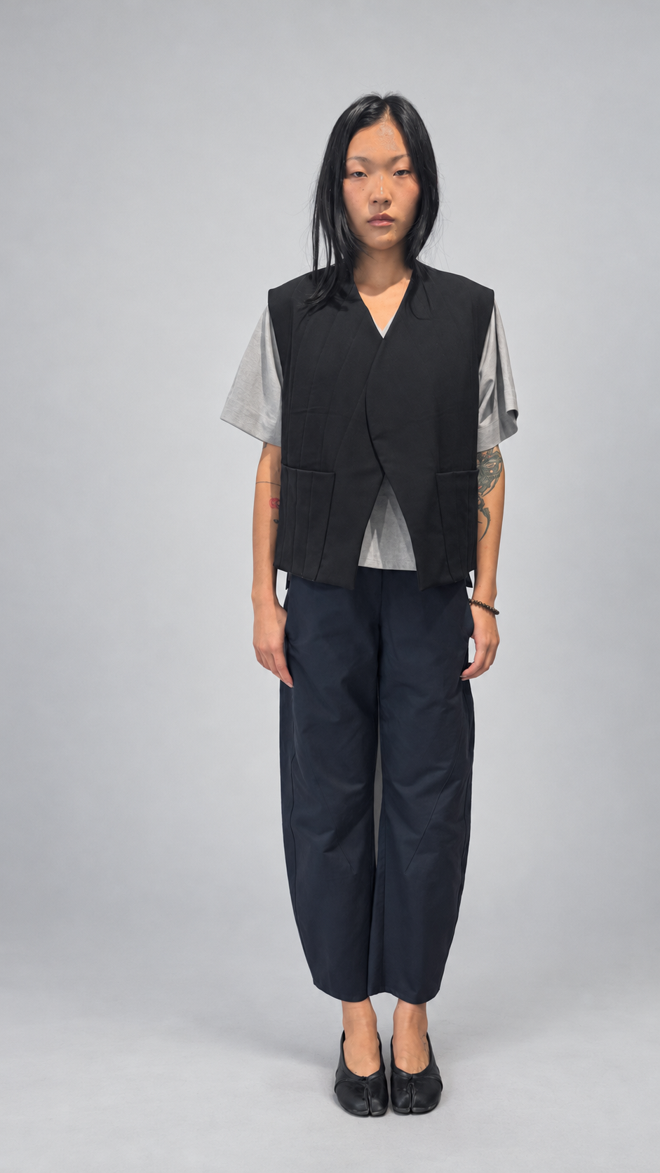 Nubi Vest Classic, Black Wool • Restocked — front model view. Anujin wearing nubi vest classic black wool, lotus shirt temple grey, twist pants berge.
