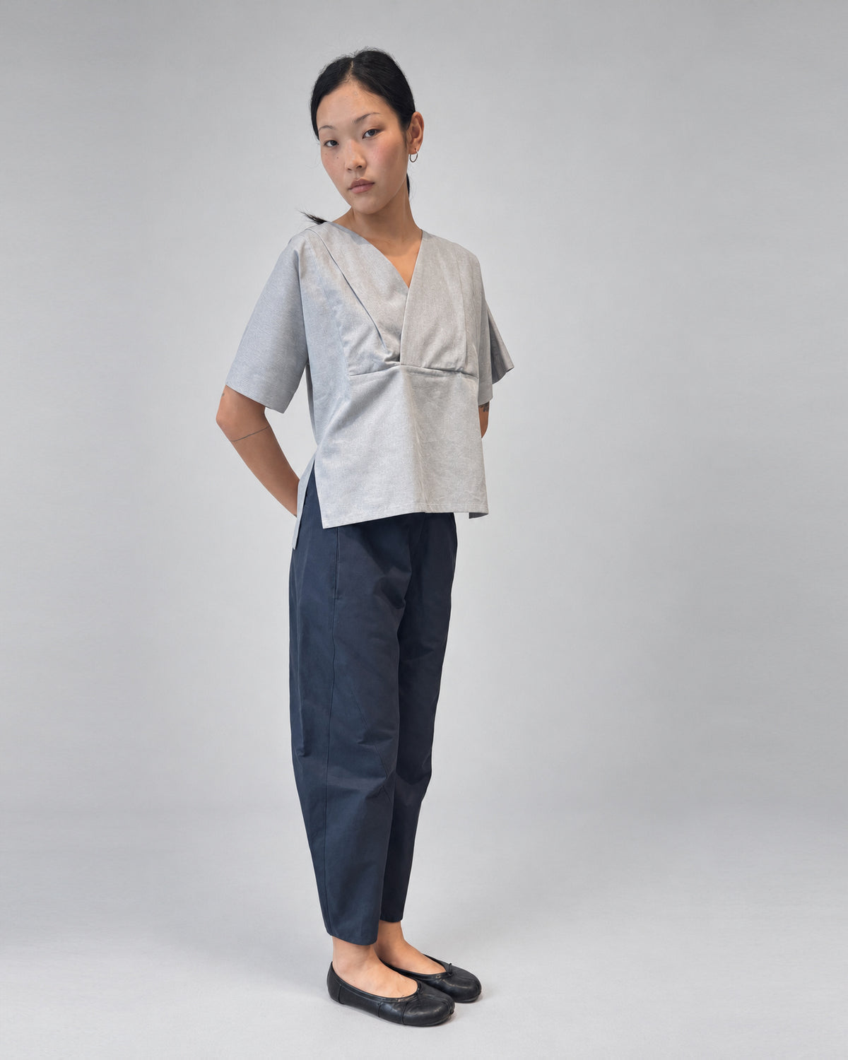 Anujin wearing Lotus Shirt, Temple Grey — three-quarter front.