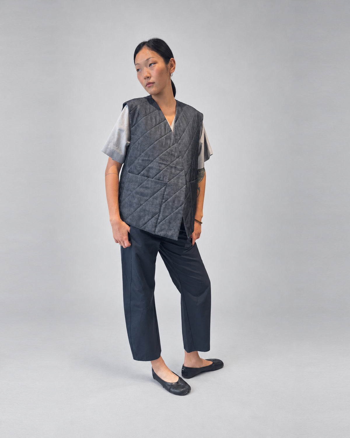 Anujin wearing Nubi Vest Wide, Dark Denim (Mens Fit) — three-quarter front.