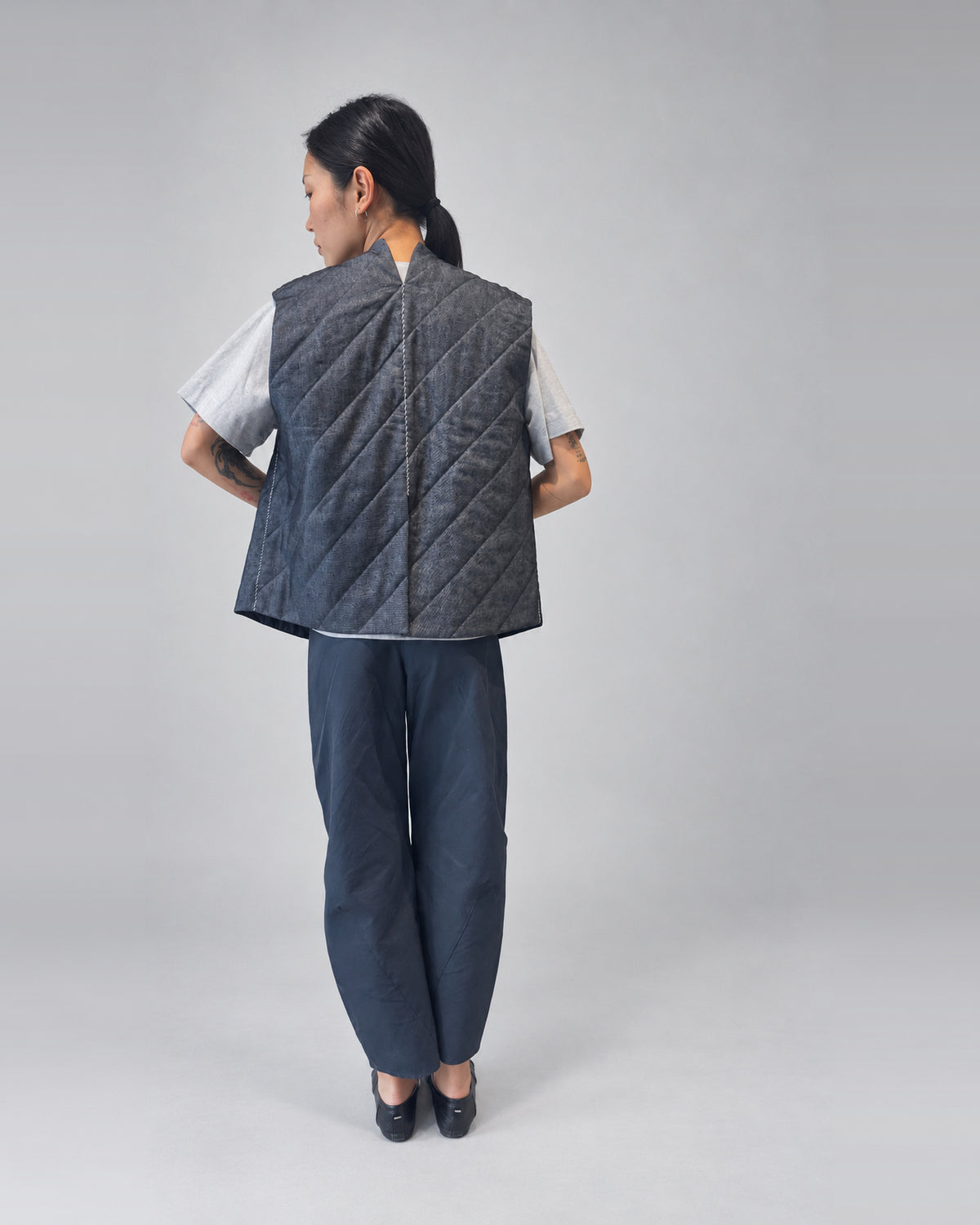 Anujin wearing Nubi Vest Wide, Dark Denim (Mens Fit) — back.