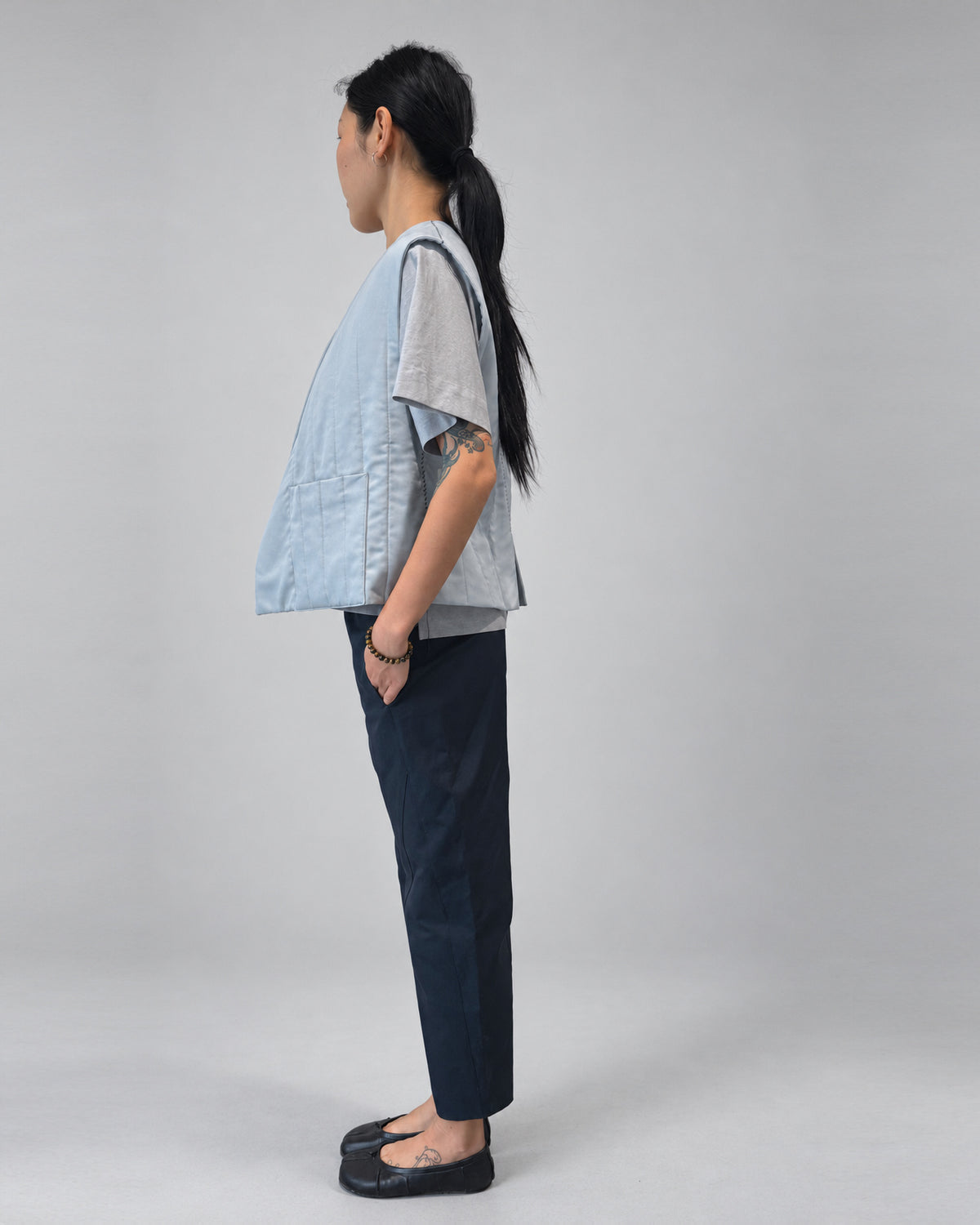 Anujin wearing Nubi Vest Classic, City Grey — side.