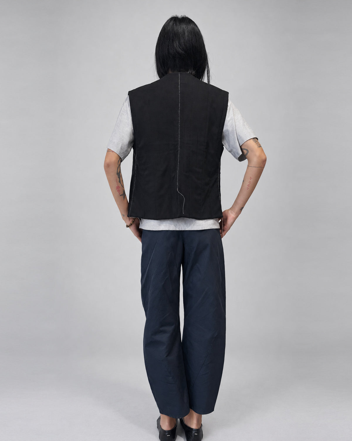 Anujin wearing Nubi Vest Classic, Black Wool — full-length back.